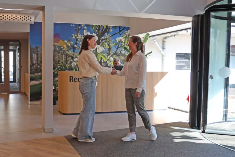 Twee vrouwen schudden elkaar de hand bij de receptie van gemeente Lingewaard