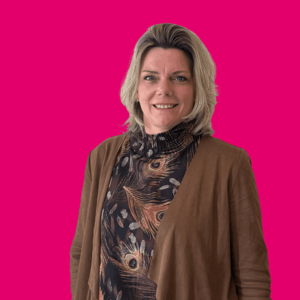 Dame poseert voor een foto. Achtergrond is een effen roze kleur